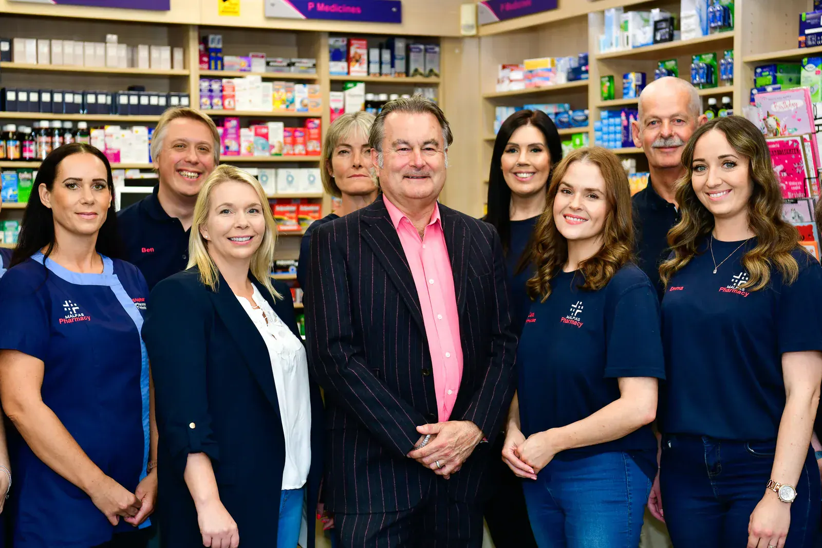 The Malpas Pharmacy team in Newport standing together behind the counter